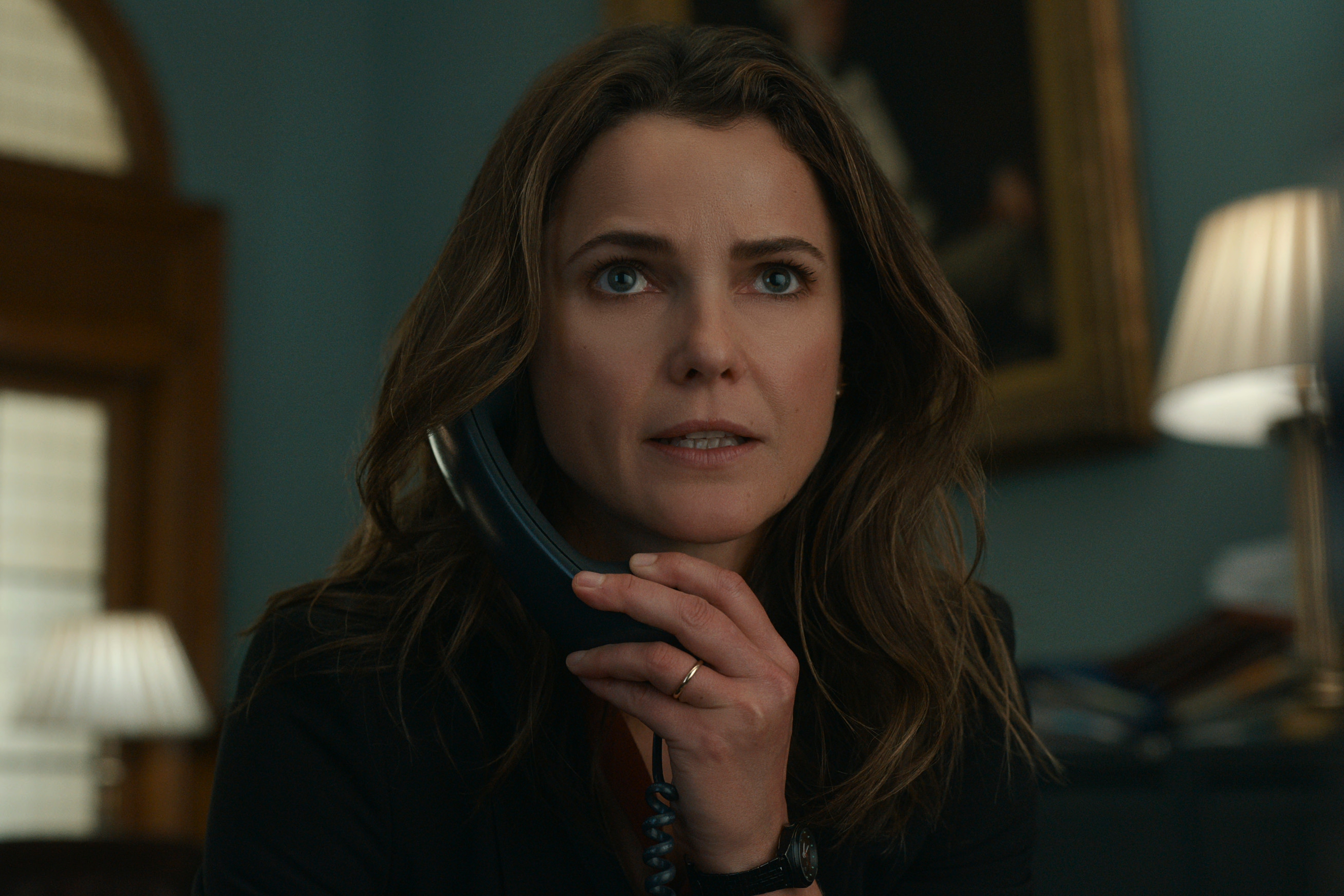 Keri Russell looks surprised while on the phone in The DIplomat